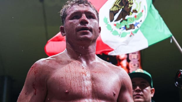 Canelo Alvarez celebrates a victory as his famed boxing trainer Eddy Reynoso looks on.